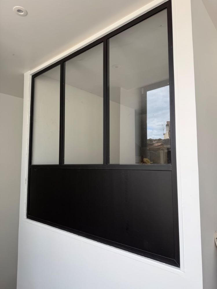 Verrière d’atelier en acier noir posée en cloison intérieure